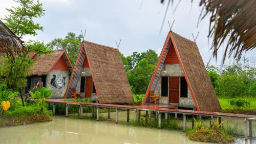 a house in the middle of a body of water at Rice Wonder Cafe & Eco Resort in Rayong