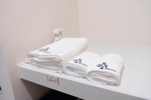 a pile of towels sitting on top of a shelf at HANASTAY花渓居 · 尺八（SYAKUHACHI) in Osaka