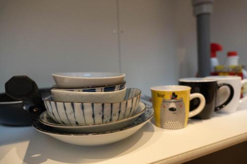 a pile of bowls and cups sitting on a counter at HANASTAY花渓居 · 尺八（SYAKUHACHI) in Osaka