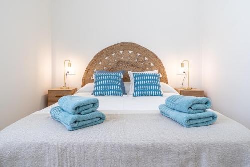 ein Schlafzimmer mit einem Bett mit blauen Kissen in der Unterkunft Coral Beach by Pat in Calafell