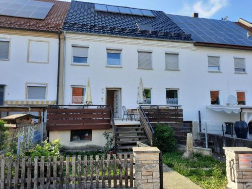 a white house with solar panels on the roof at Ferienwohnungen Donaumoos in Günzburg