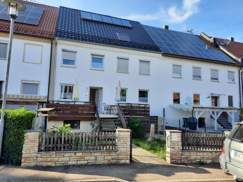 a white house with solar panels on the roof at Ferienwohnungen Donaumoos in Günzburg