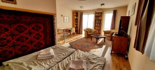 Zimmer mit einem Bett und einem Wohnzimmer mit einem Tisch in der Unterkunft Sofia Apartment Kázmér in Budapest