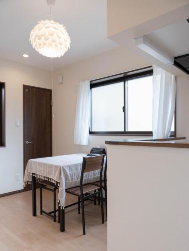 a dining room with a table and chairs and a chandelier at HANASTAY花渓居 · 尺八（SYAKUHACHI) in Osaka