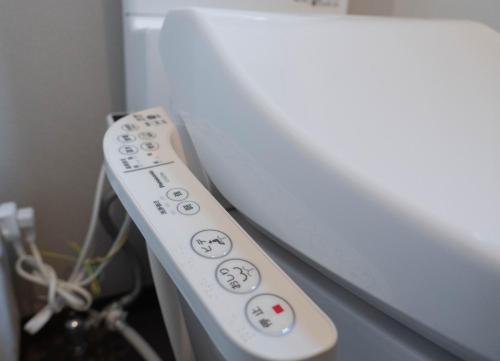a white remote control sitting next to a tv at HANASTAY花渓居 · 尺八（SYAKUHACHI) in Osaka