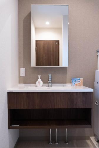 a bathroom with a sink and a mirror at HANASTAY花渓居 · 尺八（SYAKUHACHI) in Osaka