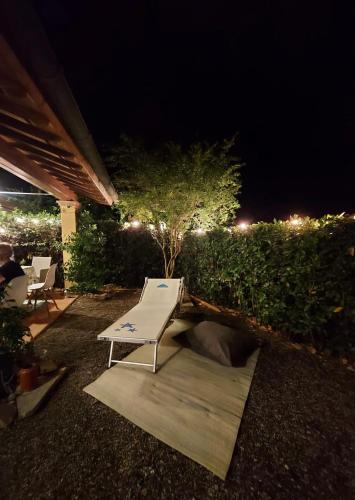 a white bench sitting on a patio at night at Piccolo Borgo Toscano relax in Monteverdi Marittimo