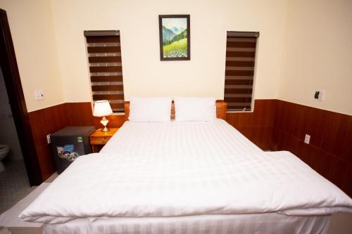 a bedroom with a large bed with white sheets at Amazing Hotel, Trương Pháp, Quang Phú, Đồng Hới in Dong Hoi