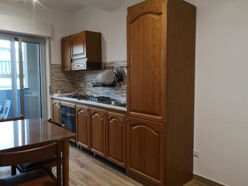 a kitchen with wooden cabinets and a wooden table and a tableablish at Le Cassiere DNA in Roccalumera