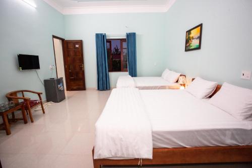 a bedroom with two beds and a television in it at Amazing Hotel, Trương Pháp, Quang Phú, Đồng Hới in Dong Hoi