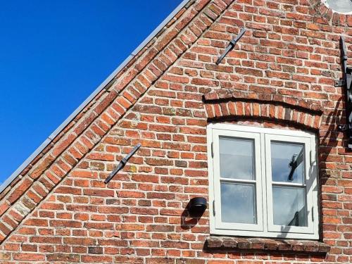 a window on the side of a brick building at Ferienhaus Galerie No 5 in Garding
