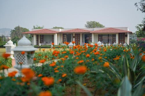 a house with a garden of orange flowers at Sariska Safari Lodge in Thāna Ghāzi