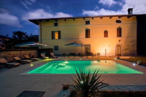 a villa with a swimming pool in front of a building at Casa Pellis in Fagagna