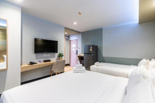 a hotel room with two beds and a flat screen tv at Hi Sotel - SHA Plus in Makkasan