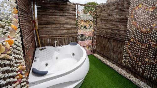 a bathroom with a white tub and a wall of wine bottles at Rice Wonder Cafe & Eco Resort in Rayong