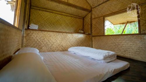 a small bedroom with a bed in a tent at Rice Wonder Cafe & Eco Resort in Rayong