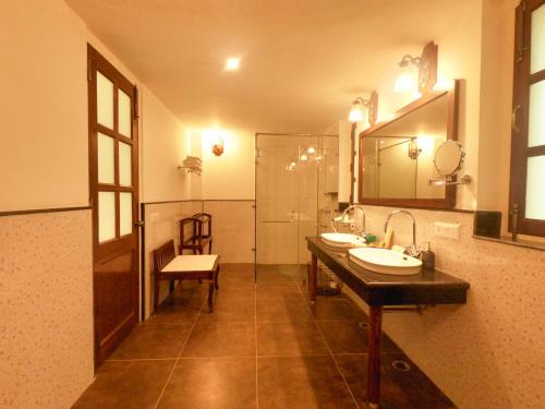 ein Badezimmer mit zwei Waschbecken, einem Spiegel und einer Dusche in der Unterkunft Sariska Safari Lodge in Thāna Ghāzi