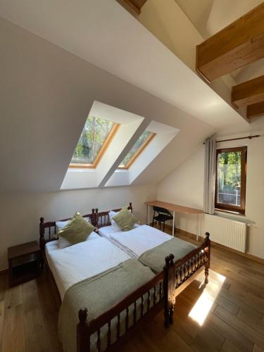 a bedroom with a bed in a room with skylights at Kersko Apartments in Hradišťko