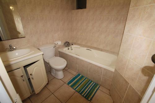 a bathroom with a toilet and a tub and a sink at Boulevard 4 in Margate