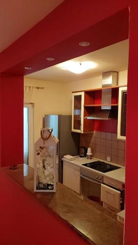 ラブにあるApartmani Katatinaの赤い壁のキッチン(赤いカウンタートップ付)