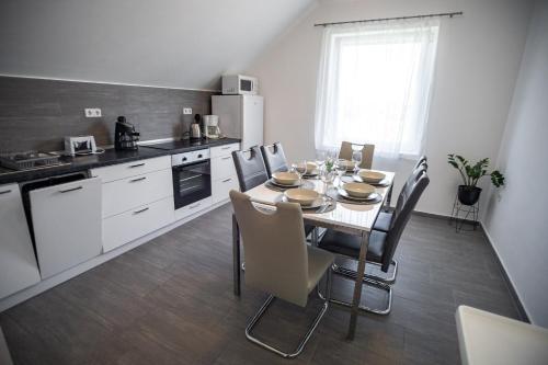 eine Küche mit einem Tisch und Stühlen im Zimmer in der Unterkunft Olivér 22 Apartman in Fonyód