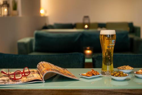 a table with a glass of beer and a book at Prima Galil Tiberias Hotel in Tiberias