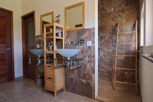 y baño con 2 lavabos y ducha. en Les Villas Thorel, en Rivière Noire