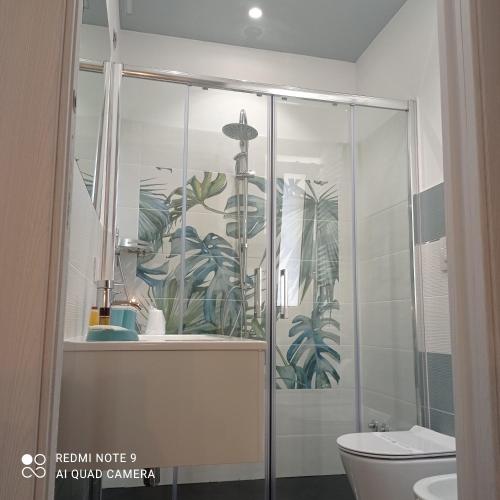 een badkamer met een glazen douche en een toilet bij Garden Gafè in Diamante