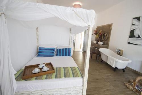 a bedroom with a bed and a tub in a room at Le Comfort (self catering) in Anse Royale