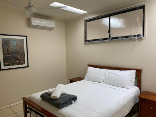 a bedroom with a white bed and a window at Cairns City Sheridan Motel in Cairns