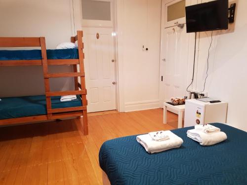 ein Schlafzimmer mit zwei Etagenbetten und einem Fernseher in der Unterkunft Maclean Hotel in Maclean