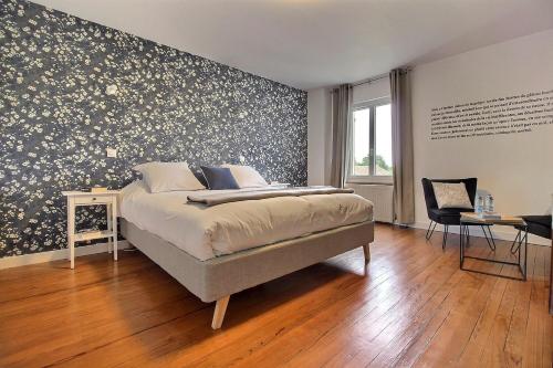 um quarto com uma cama e uma parede com papel de parede floral em Le Temps retrouvé em Concevreux