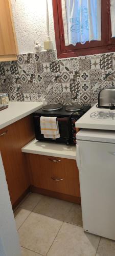 a kitchen with a counter with a stove top oven at Hotel Eliza in Agios Nikolaos