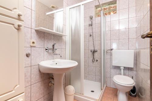 a bathroom with a sink and a toilet and a shower at Apartment Slavica with private Balcony and Parking lot in Punat