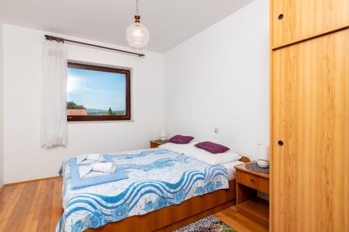 a small bedroom with a bed and a window at Apartment Slavica with private Balcony and Parking lot in Punat