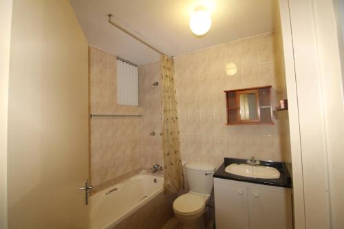 a bathroom with a toilet and a sink and a tub at Boulevard 105 in Margate
