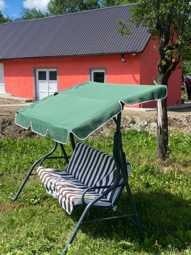 a chair with a green cover on it in front of a house at Casa Illyria in Gusinje