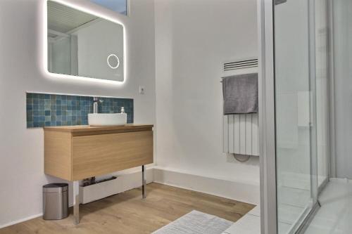 uma casa de banho com um lavatório e um espelho em Le Temps retrouvé em Concevreux