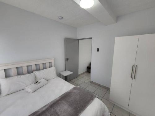 una camera bianca con un grande letto e un armadio di Grace Villas 7 a East London