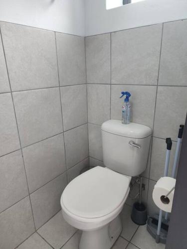 a bathroom with a toilet with a bottle on top of it at Grace Villas 7 in East London