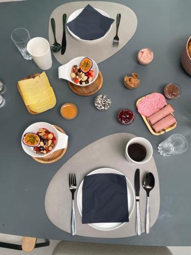 a table with utensils and plates of food on it at B&B het Notarishuis in Voeren