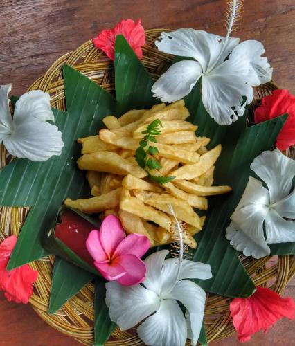 a plate of food with french fries and flowers at Sumatra Orangutan Discovery Villa in Bukit Lawang