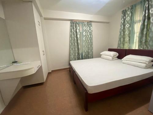 - une petite chambre avec un lit et un lavabo dans l'établissement The Palm Guest House, à Kohīma