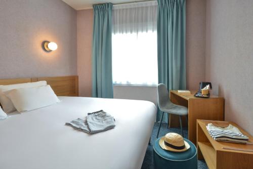 a hotel room with a bed and a desk and a window at Sure Hotel by Best Western Centre Beaune in Beaune