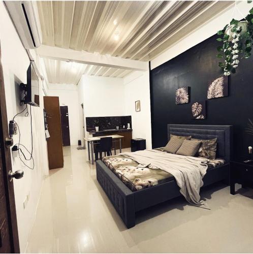 a bedroom with a bed with a black wall at Sto Niño Residences Lucena City in Lucena
