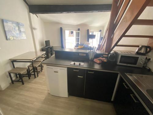 une cuisine avec un comptoir, un four micro-ondes et une table dans l'établissement Le Cocon d'Avignon - T2 Duplex 40m2 - Centre historique Intra muros- WIFI CLIMATISATION, à Avignon