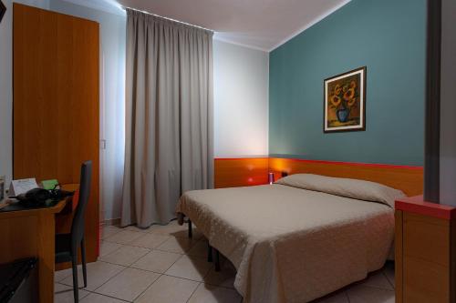 1 dormitorio con cama, mesa y escritorio en Hotel La Quercia, en Mozzo