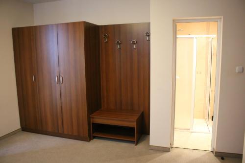 a large wooden cabinet with a bench in a room at Kralev Dvor Hotel in Bansko