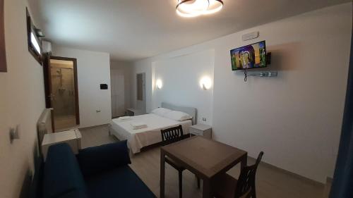 ein kleines Hotelzimmer mit einem Bett und einem Tisch in der Unterkunft Villa Saponaro - Affittacamere in Torre Lapillo