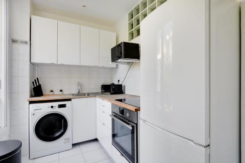 - une cuisine blanche avec lave-linge et sèche-linge dans l'établissement Charming apartment - 1BR-4P - Parc Monceau, à Paris